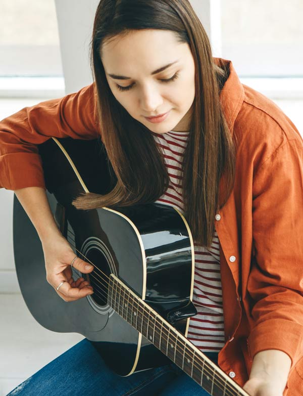 Erwachsene Frau spielt Gitarre